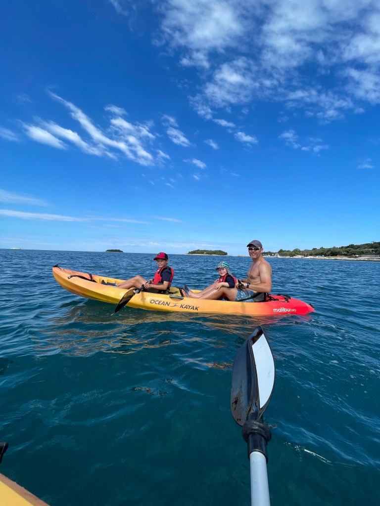 Active family kayaking in the sea in Croatia at a luxury family Croatia Campsite.