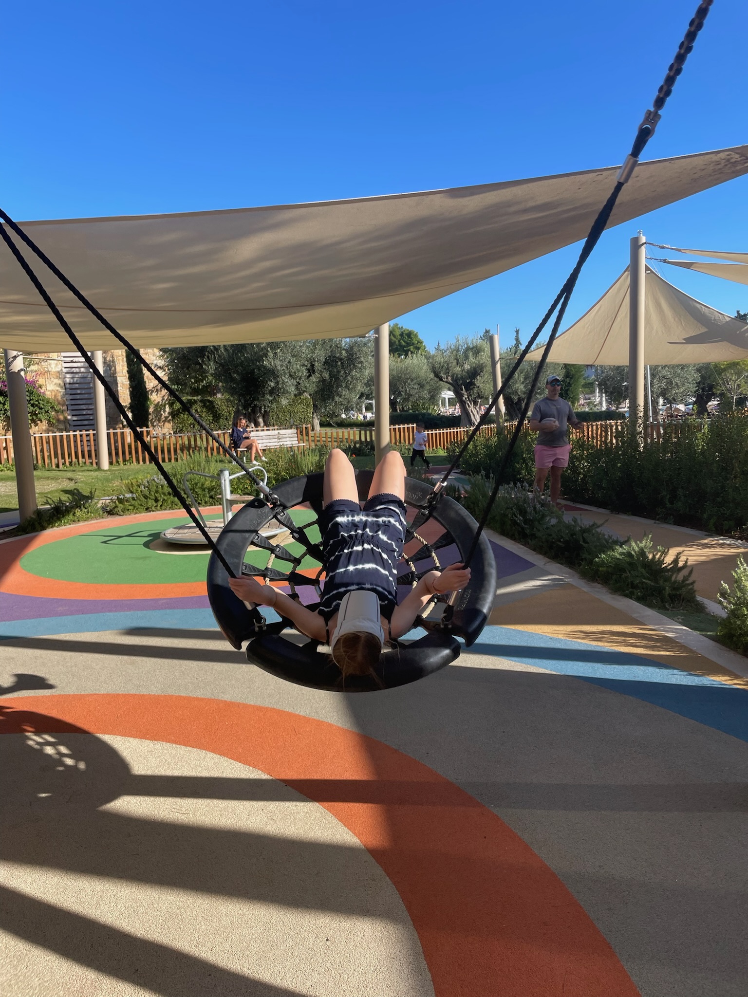 Children playing on shaded play park, Ikos Olivia