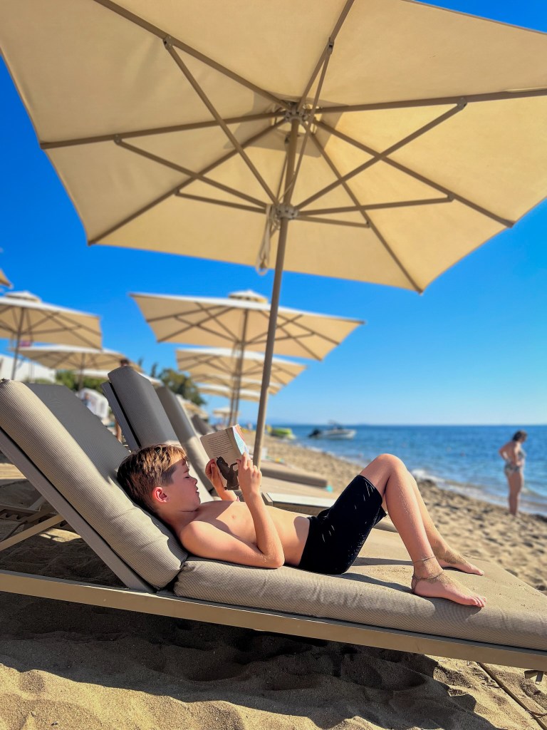 Sandy beach sunbeds at Ikos Olivia