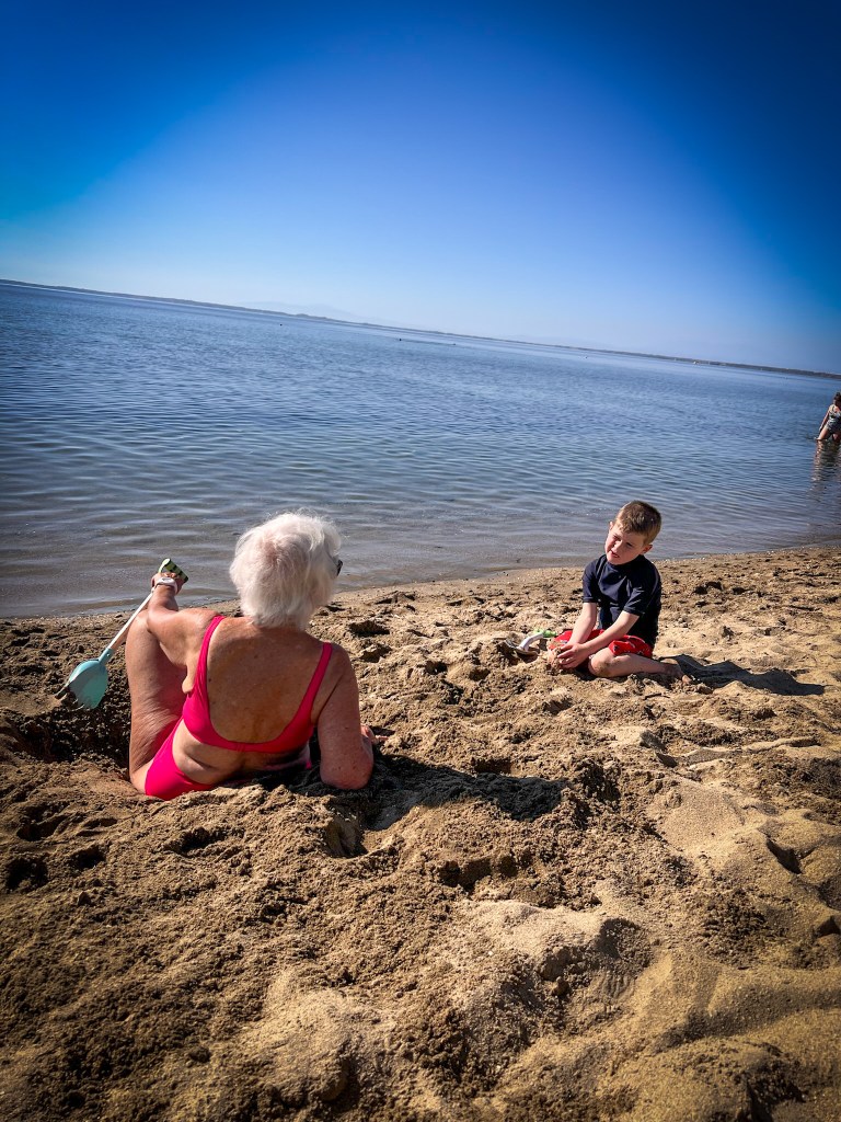 Playing with Grandma on the sandy beach at Ikos Olivia