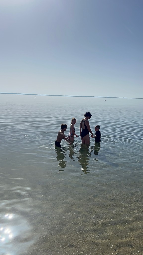 young family searching for fish on the sandy beach at Ikos Olivia