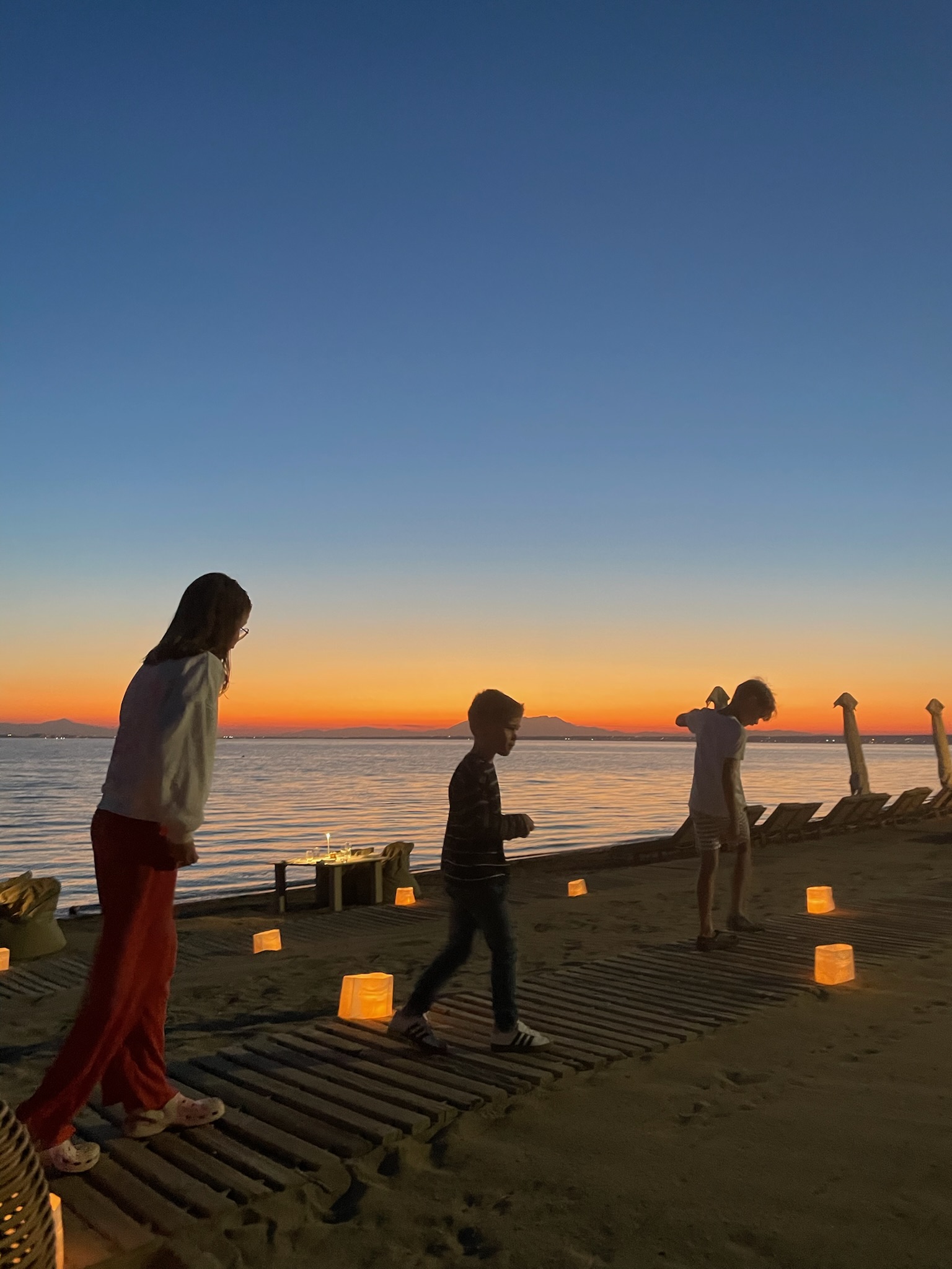 Children exploring the beach at sunset at Ikos Olivia