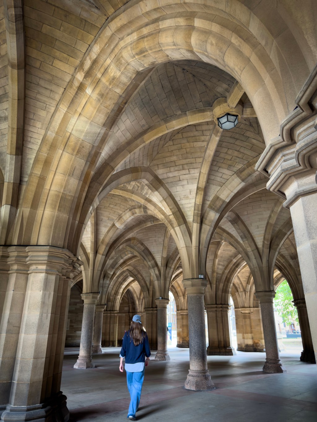 lady walking through Glasgow university cloisters
